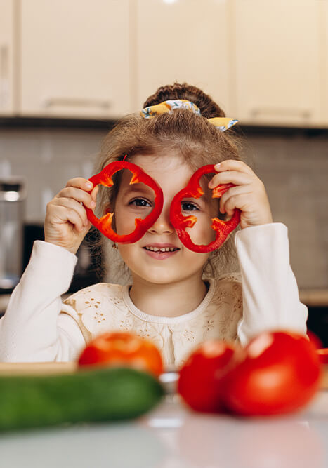 kind spielt mit paprika und gemuese in der kueche gesundes kochen mit kindern