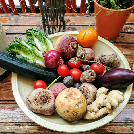 saisonales gemuese und obst auf holzteller frisch und natuerlich
