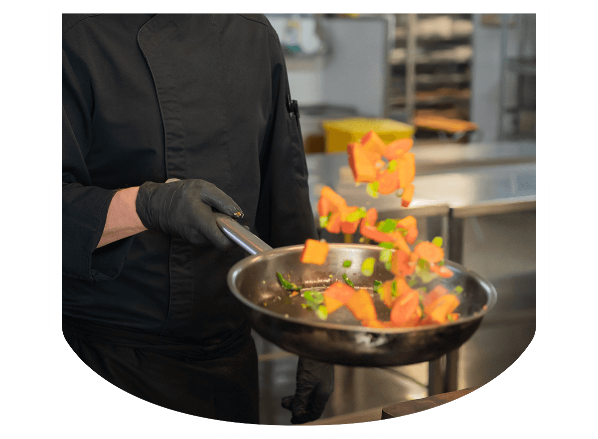 feintopf catering koch schwenkt gemuese in pfanne